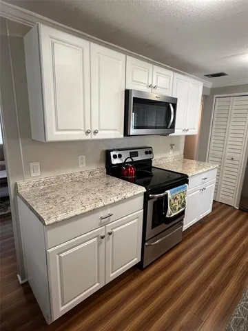 a kitchen with stainless steel appliances granite countertop a stove a sink and a microwave