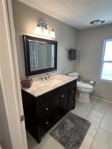 a bathroom with a sink vanity and a toilet