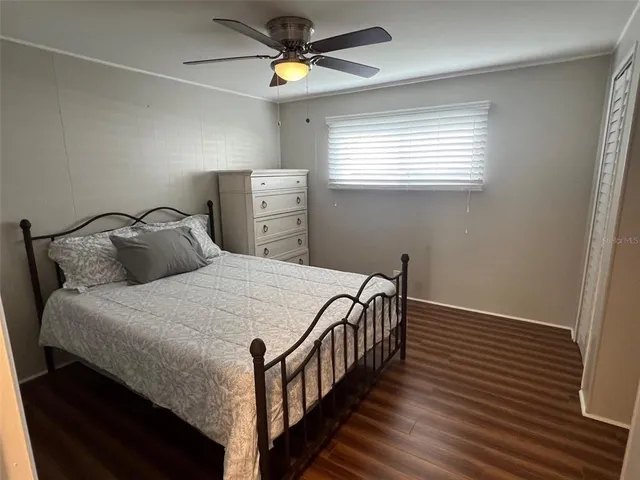 a bedroom with a bed and a ceiling fan