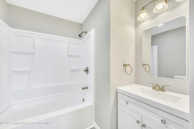 a bathroom with a bathtub sink vanity and mirror