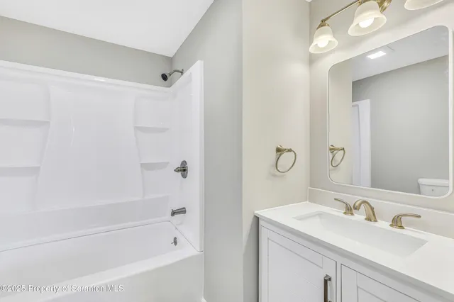 a white bath tub sitting next to a bathroom sink