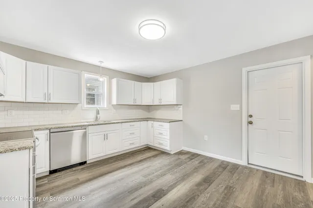 a kitchen with granite countertop white cabinets and white appliances