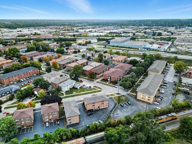 an aerial view of a city with lots of residential buildings and ocean view in back
