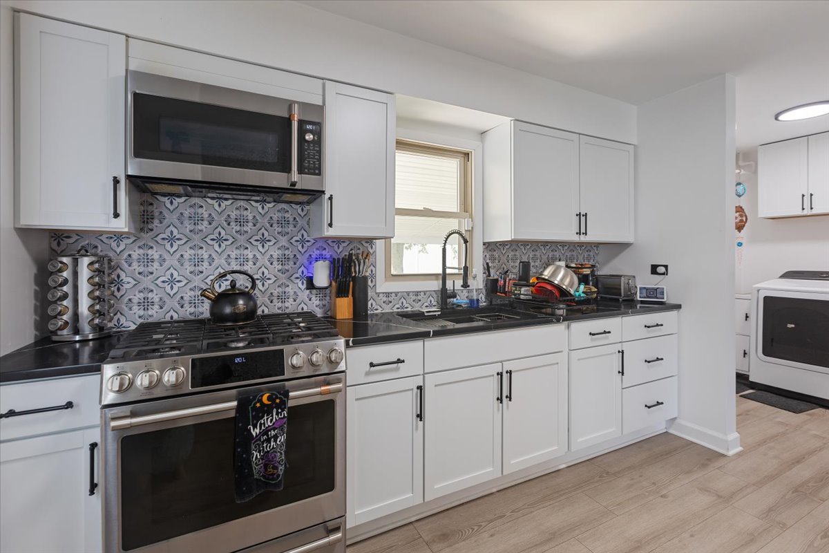 7506 Ferdinand Avenue Bridgeview, IL 60455 - Photo 13 of 32 a kitchen with granite countertop white cabinets stainless steel appliances and a sink