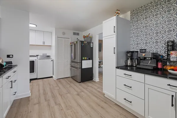 a kitchen with stainless steel appliances a refrigerator sink and cabinets