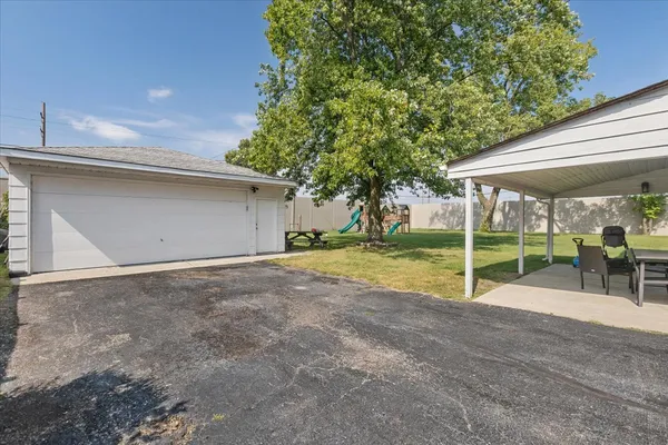 a view of a backyard with floor to ceiling window and a tree