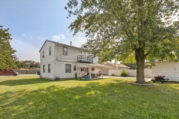a view of a house with a big yard and large tree
