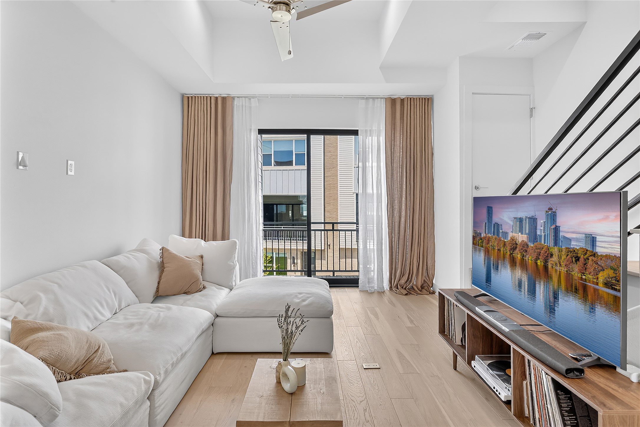2805 McCurdy Street, Unit 14 Austin, TX 78723 - Photo 5 of 40 A living space with light wood flooring and a modern balcony provides an inviting, comfortable atmosphere.