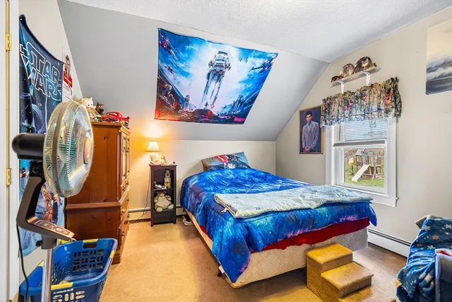 a bedroom with bed and a painting on the wall