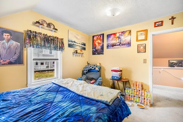 a bedroom with a bed and a view of kitchen