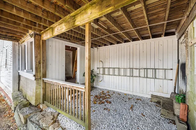 a porch with chairs and potted plant