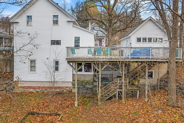 a view of a house with a yard and large tree