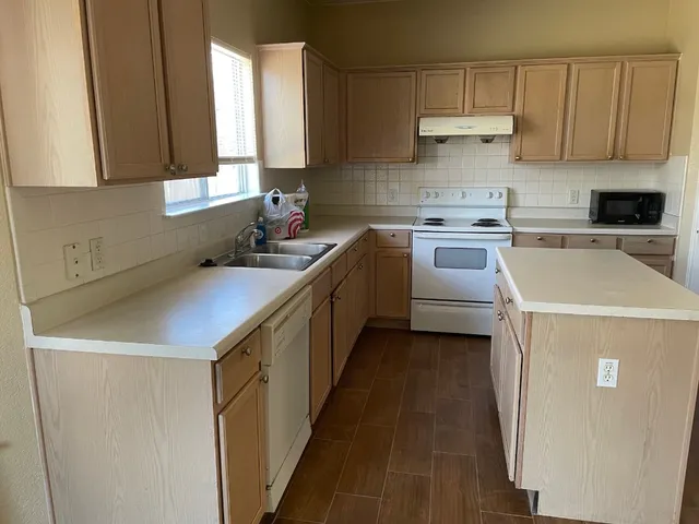 a kitchen with a sink a stove and cabinets