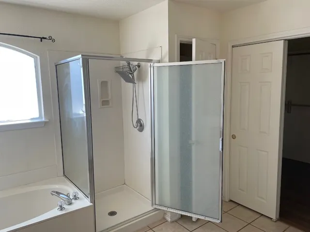 a bathroom with a shower and a glass door