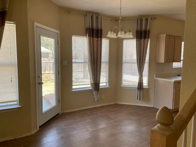 a view of a kitchen with a refrigerator wooden floor and a window