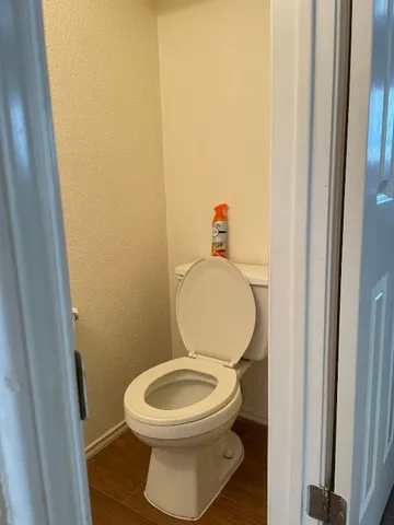 a white toilet sitting next to a wooden cabinet
