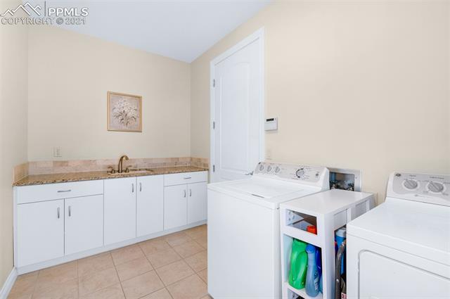 6980 Wildridge Road Colorado Springs, CO 80908 - Photo 12 of 26 The main-level laundry room includes cabinets with sink & granite counter.