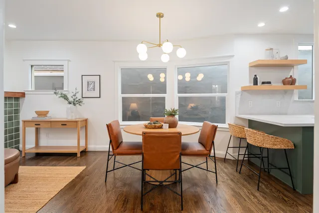 a living room with stainless steel appliances kitchen island granite countertop furniture a sink a rug and a window