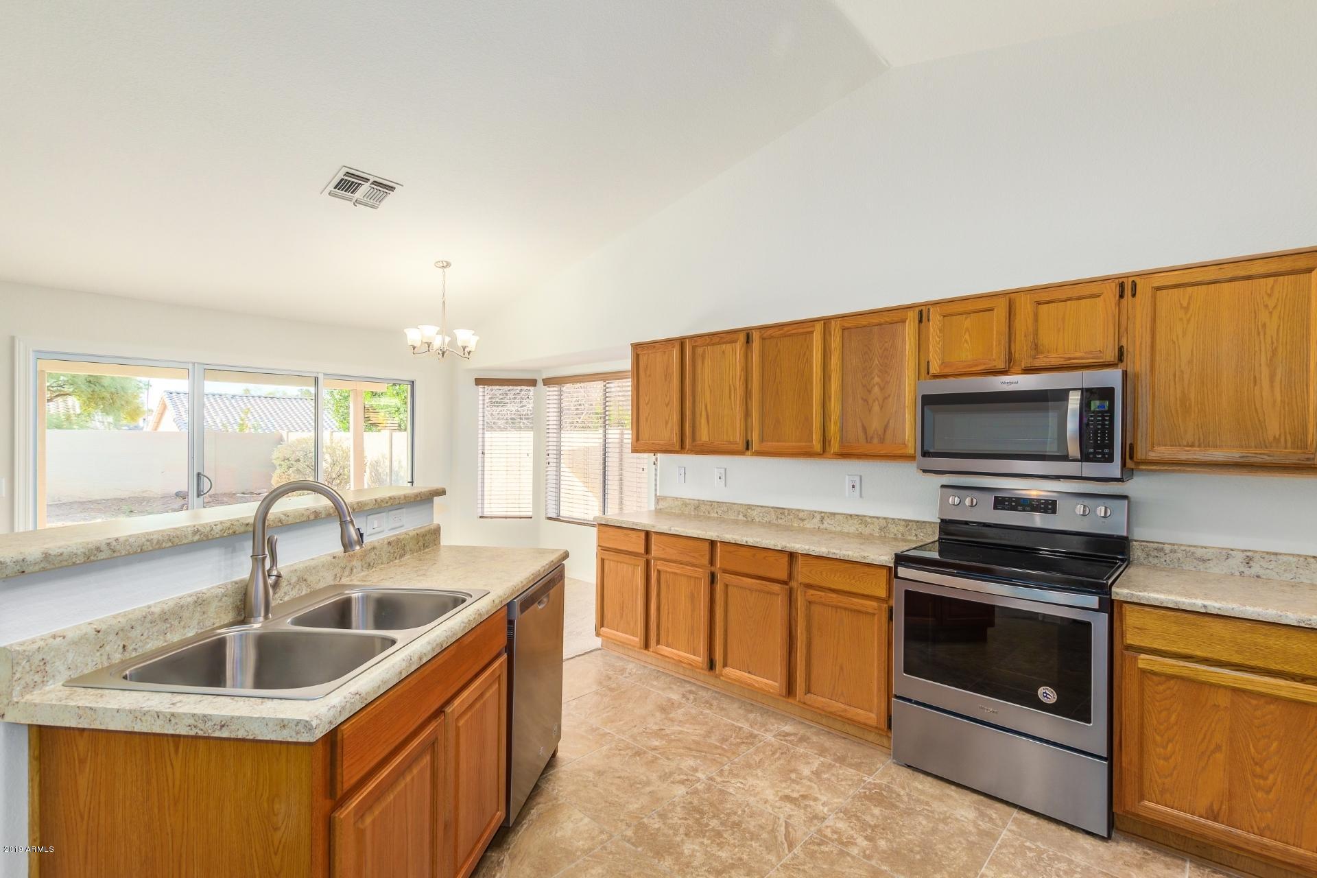 213 West Marco Polo Road Phoenix, AZ 85027 - Photo 6 of 21 a kitchen that has a sink and a stove top oven