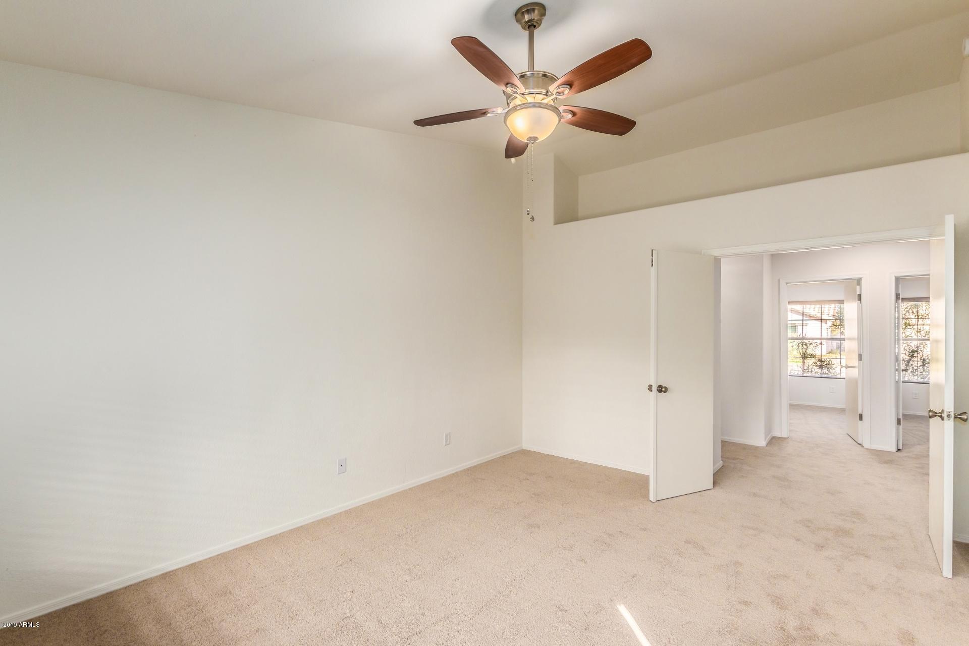 213 West Marco Polo Road Phoenix, AZ 85027 - Photo 9 of 21 an empty room with a ceiling fan and a view of bathroom