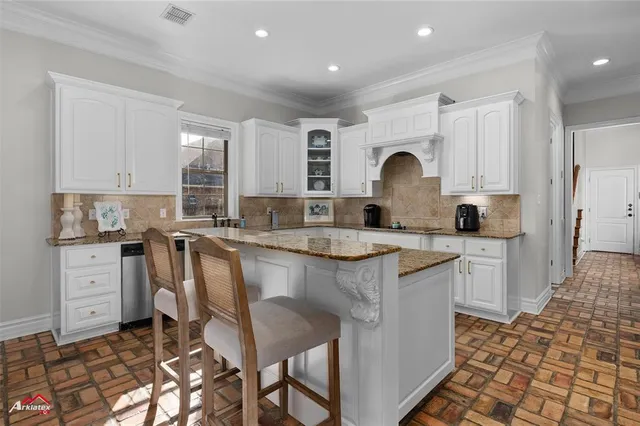 a kitchen with granite countertop a sink stove and cabinets