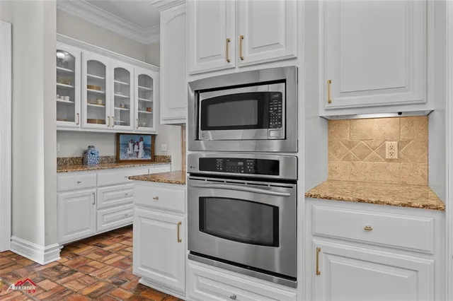 a kitchen with granite countertop white cabinets stainless steel appliances and sink