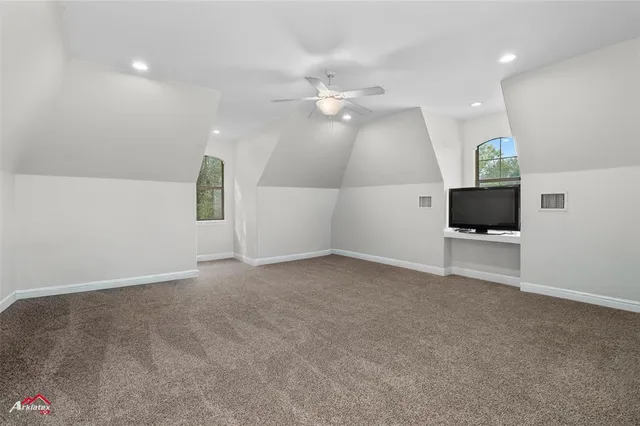 an empty room with windows and fireplace