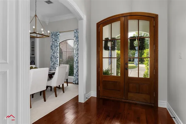 a view of a hallway with wooden floor and windows