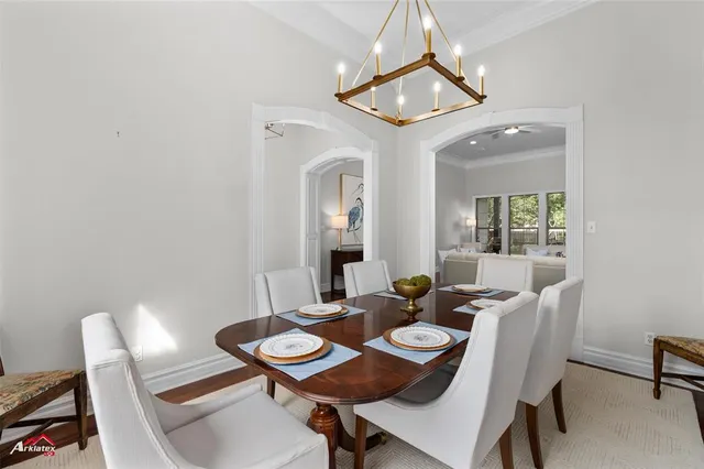 a view of a dining room with furniture and a chandelier fan