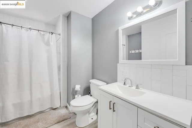 a bathroom with a sink a toilet and shower curtain