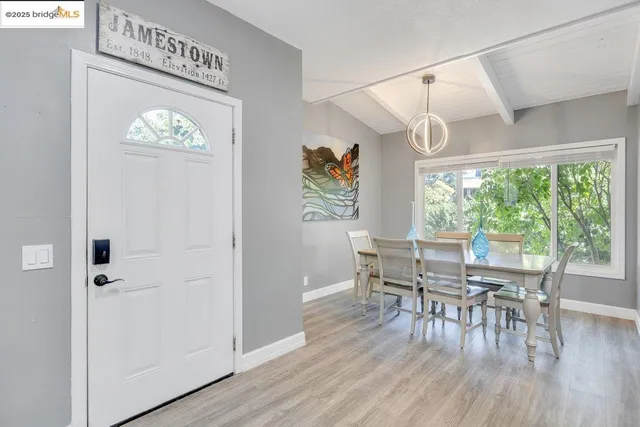 a dining room with furniture entryway and wooden floor