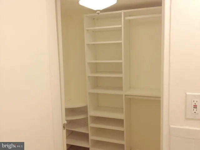 a view of walk in closet with empty racks