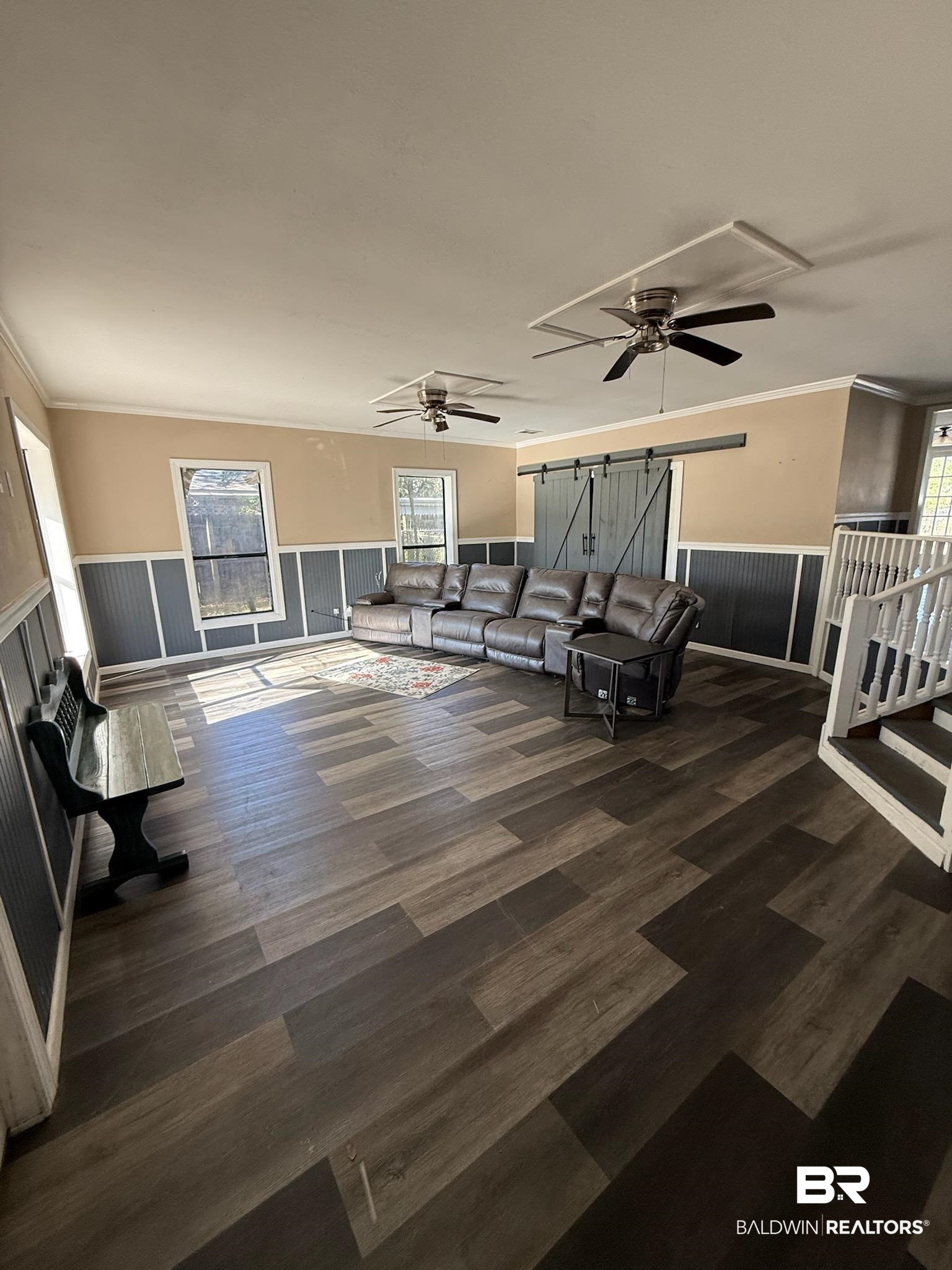 6745 Carol Plantation Road Theodore, AL 36582 - Photo 4 of 13 Living area featuring ceiling fan, a wainscoted wall, ornamental molding, dark wood-type flooring, and a barn door
