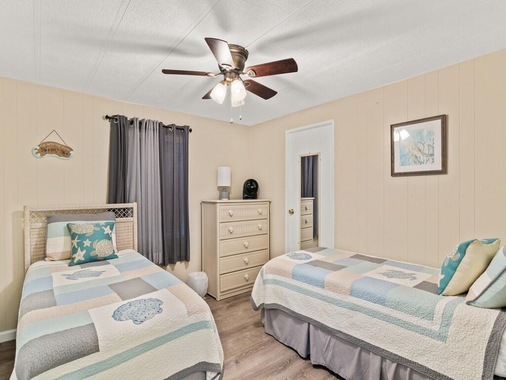 4800 Southeast Federal Highway, Unit 76 Stuart, FL 34997 - Photo 16 of 32 a bedroom with a large bed and a chandelier