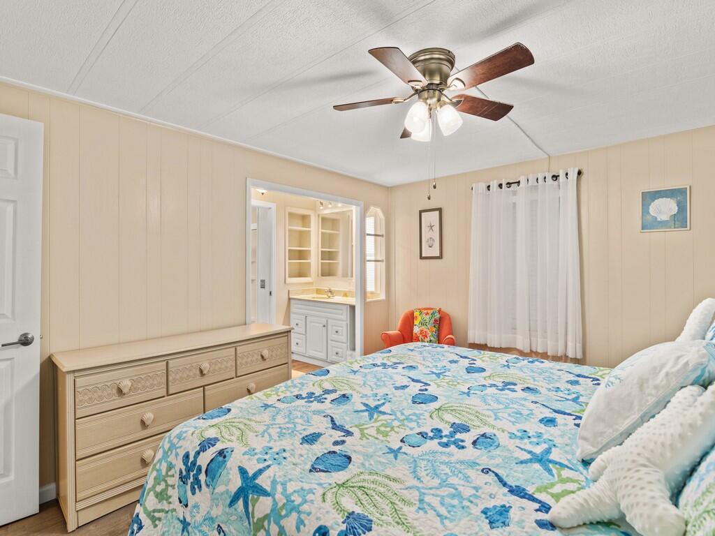 4800 Southeast Federal Highway, Unit 76 Stuart, FL 34997 - Photo 18 of 32 a bedroom with a bed and a chandelier