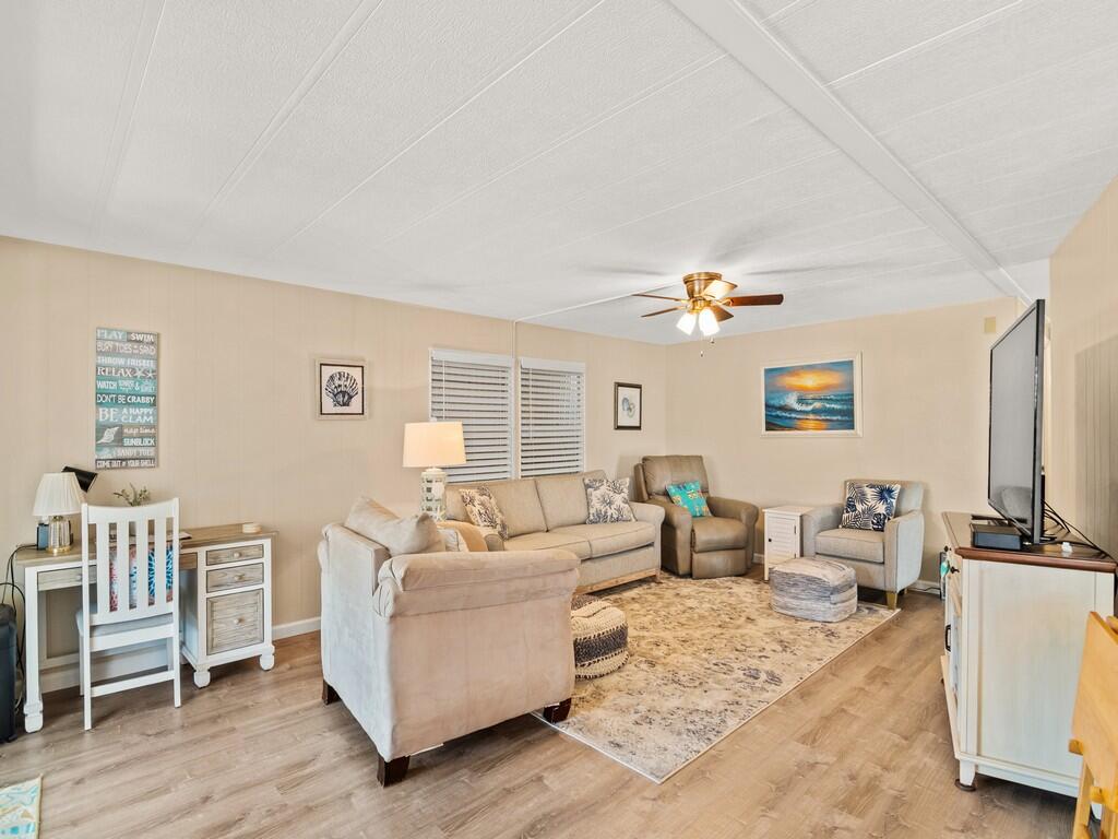 4800 Southeast Federal Highway, Unit 76 Stuart, FL 34997 - Photo 7 of 32 a living room with furniture a flat screen tv and a table