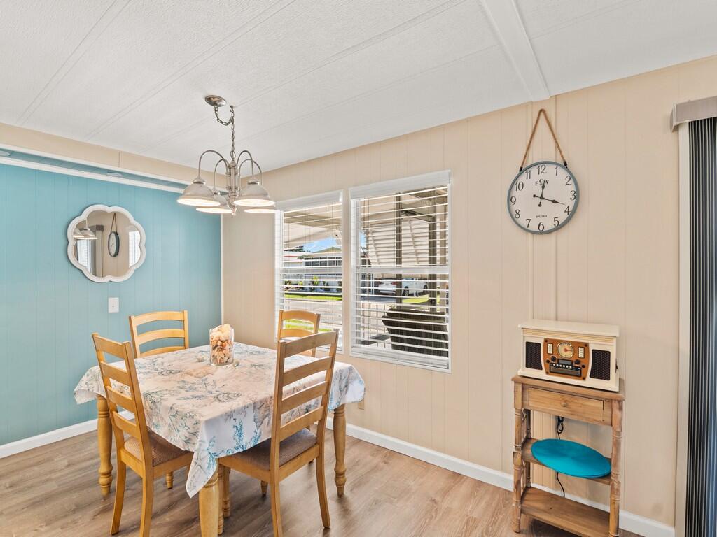 4800 Southeast Federal Highway, Unit 76 Stuart, FL 34997 - Photo 10 of 32 a view of a dining room with furniture a chandelier and wooden floor