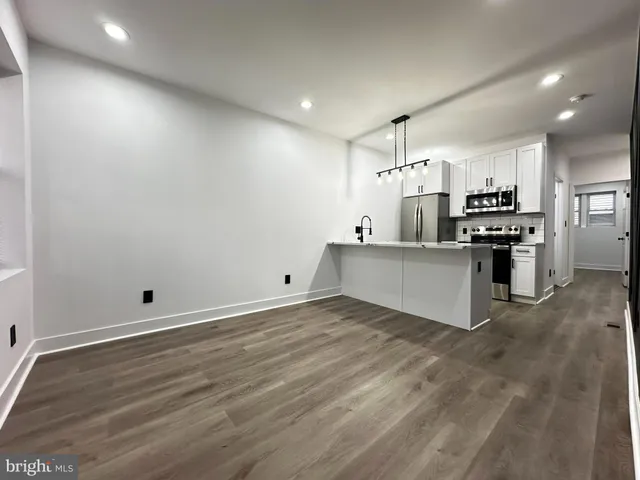 a view of a kitchen with stainless steel appliances a refrigerator and a stove top oven