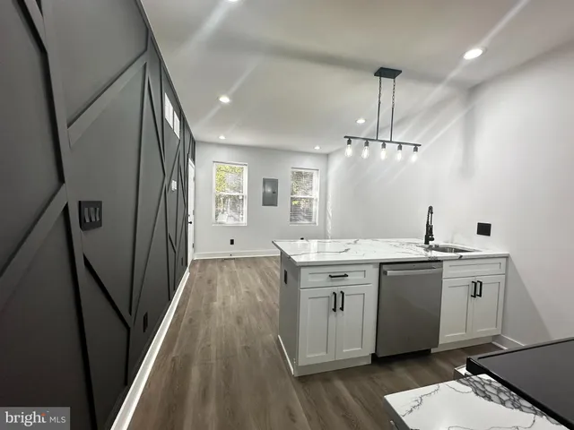 a spacious bathroom with a granite countertop sink a mirror and a bathtub