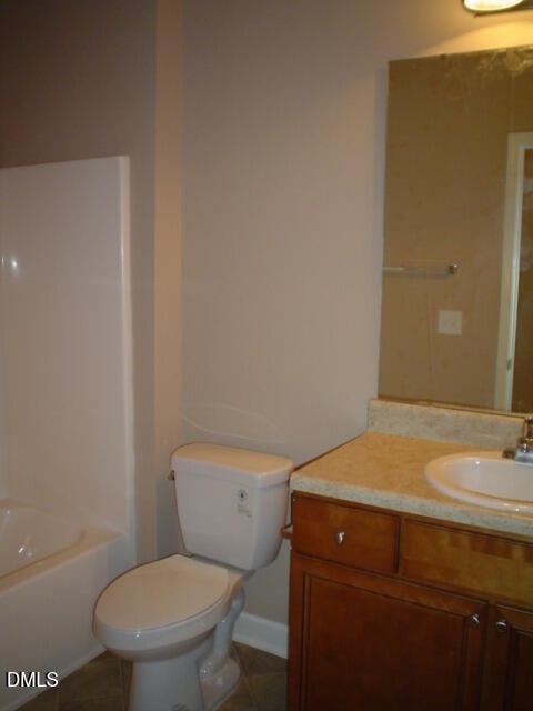 3722 Burt Drive, Unit 306 Raleigh, NC 27606 - Photo 7 of 9 a bathroom with a granite countertop toilet and a sink