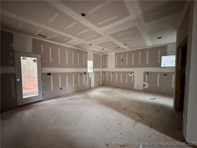 a view of an empty room with a fireplace and a window