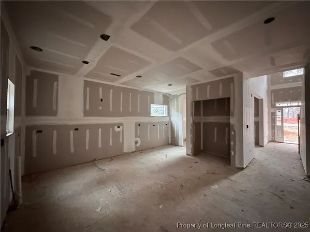 a view of an empty room with a fireplace and a window