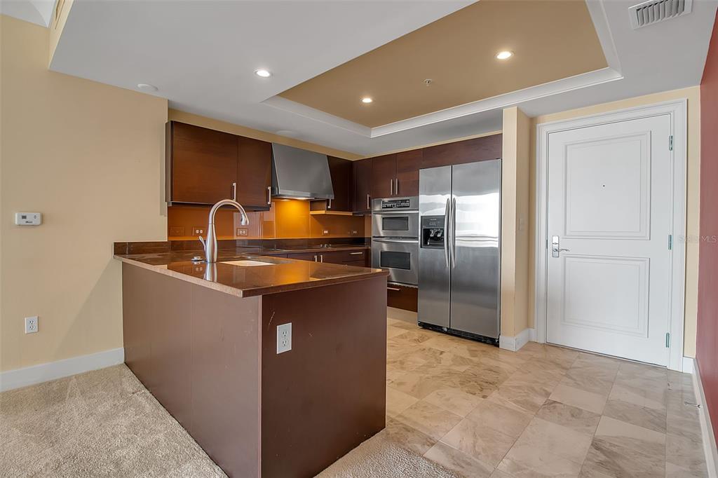 1350 Main Street, Unit 707 Sarasota, FL 34236 - Photo 14 of 68 a kitchen with granite countertop a refrigerator and a sink