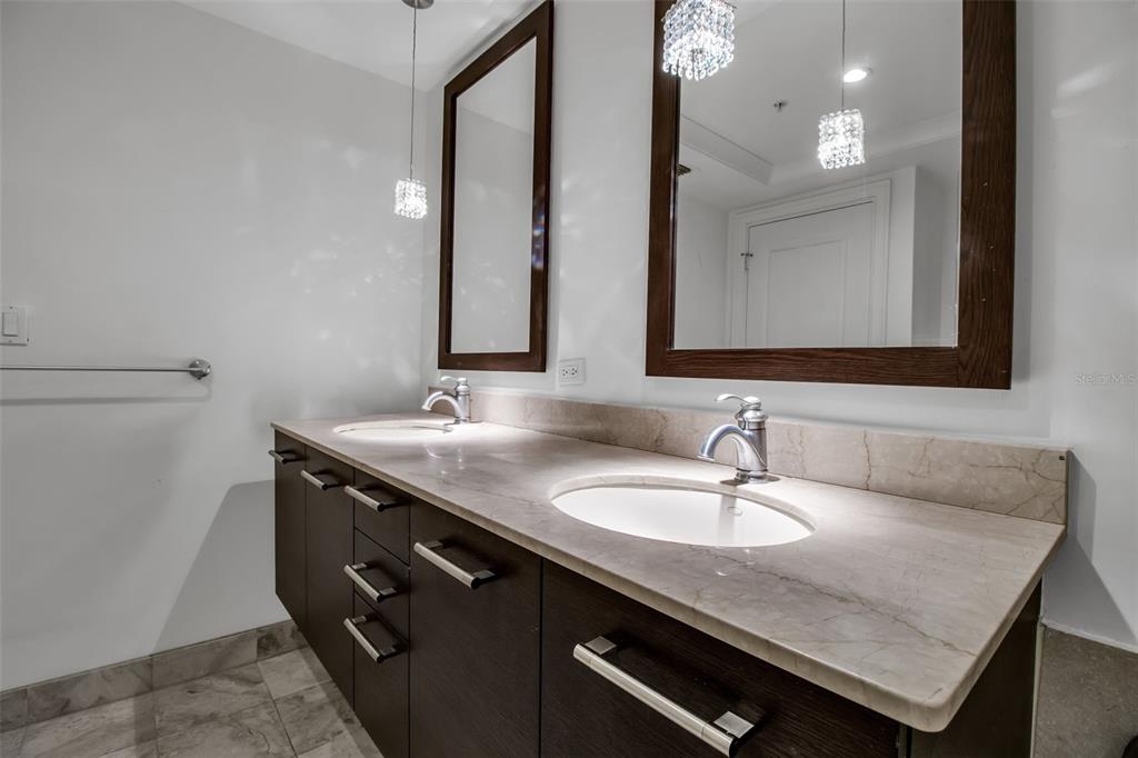 1350 Main Street, Unit 707 Sarasota, FL 34236 - Photo 37 of 68 a bathroom with a granite countertop sink a mirror and a vanity