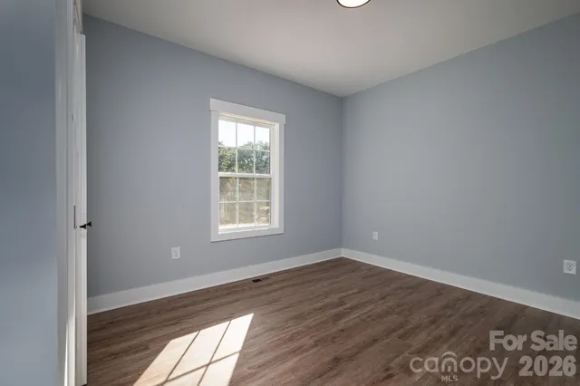 an empty room with wooden floor and a window