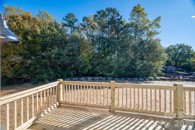 a backyard of a house with wooden fence and a tree