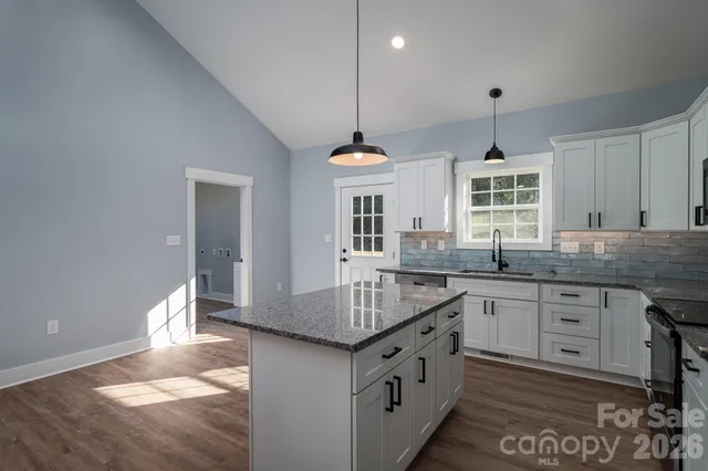 a kitchen with granite countertop white cabinets and stainless steel appliances