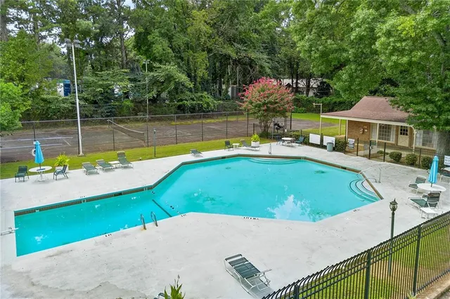 a view of a swimming pool with a patio and a yard