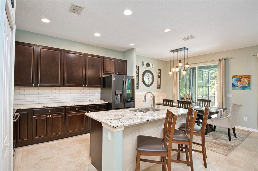 1111 Spruce Ridge Court Minneola, FL 34715 - Photo 12 of 34 a kitchen with a sink and chairs