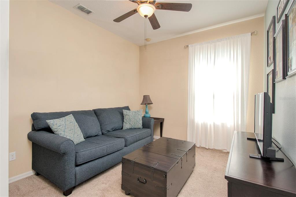 1111 Spruce Ridge Court Minneola, FL 34715 - Photo 21 of 34 a living room with furniture and a flat screen tv